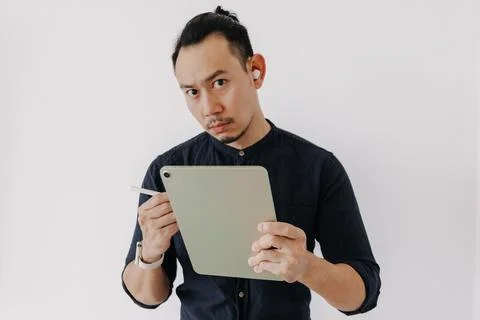 Creative freelance man with earbuds work with tablet isolate on white. Foto stock