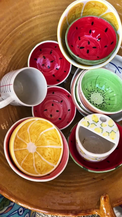 Creative Fruit-Themed Ceramic Bowls and Serving Dishes Stacked on a Table Stock Footage 345078362