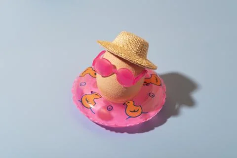 Creative fun Easter concept with an egg on a swimming inflatable circle 库存照片