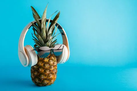 Creative funny pineapple face wearing sunglasses headphones. Pineapple face l Stock Photos