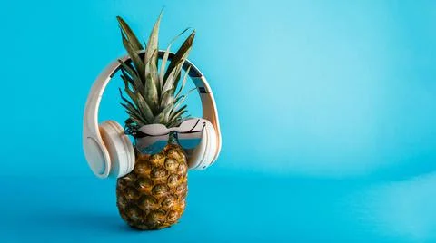 Creative funny pineapple face wearing sunglasses headphones. Pineapple face Stock Photos