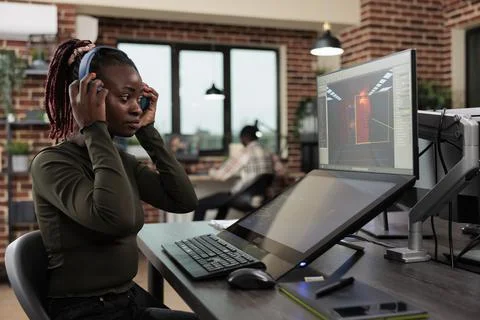 Creative game developer following CGI render on computer screen while analyzing Stockfoto's