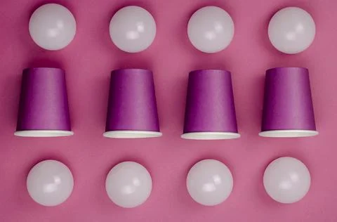 Creative geometric composition with paper cups and white spheres on coral bac Stock Photos