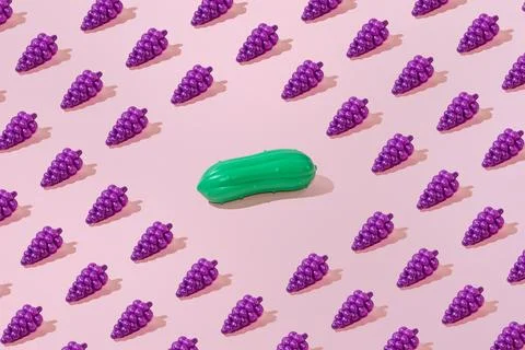 Creative grape and cucumber pattern flat lay pastel pink background minimalis Stock Photos