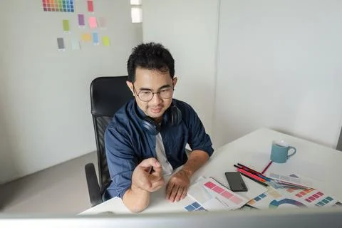 Creative Graphic Designer Working in Modern Design Studio with Color Swatches Foto stock