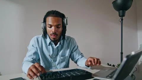 Creative guy typing console indoors closeup. Black hair sound engineer mixing Foto stock