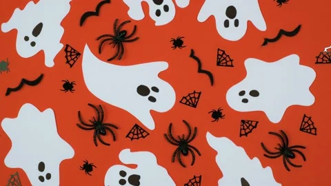 Creative halloween decorations randomly lie on a rotating orange background. 4k. Stock Footage 213395405
