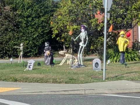 A creative Halloween yard display featuring skeletons on a lawn Stock Photos