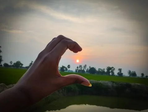 Creative Hand Gesture Framing the Sunset Stock Photos