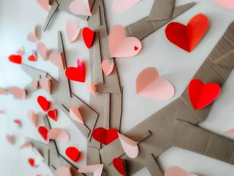 A creative handmade tree made of cardboard branches is decorated with red Stock Photos