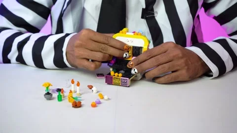 Creative Hands with Halloween Nails Crafting Lego Designs Indoors Stock Footage 328293853