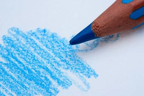 Creative hands at work with blue crayon on paper Stock Photos
