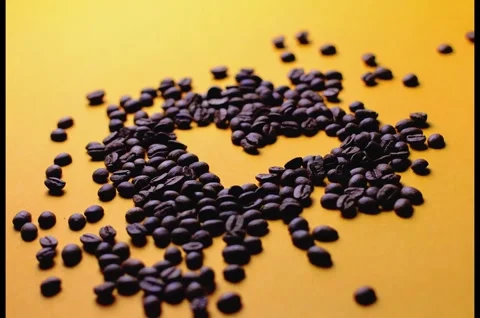 Creative heart shape made of roasted coffee beans on bright yellow background Stock Footage 330586624