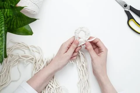 Creative hobby handmade macrame for home decoration. Girl weaves macrame. Wom Foto stock