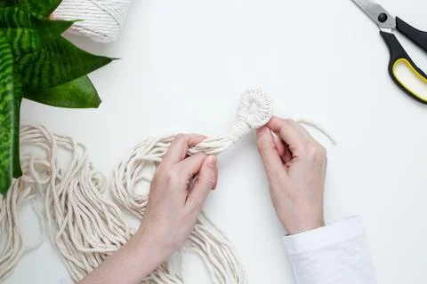 Creative hobby handmade macrame for home decoration. Girl weaves macrame. Wom Stock Photos