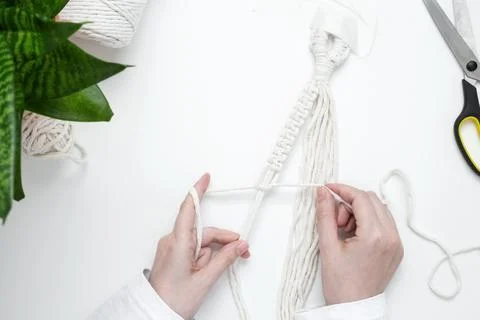 Creative hobby handmade macrame for home decoration. Girl weaves macrame. Wom Stock Photos
