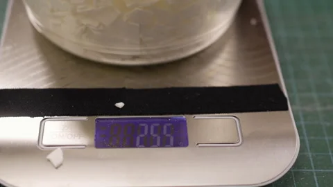 Creative hobby at home. Candlemaker weighing wax flakes on a digital scale Video stock 329417905