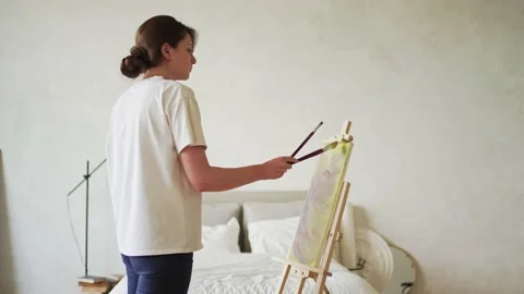 Creative hobby. Inspiration and creativity. A young woman paints a picture Stock Footage 157150104