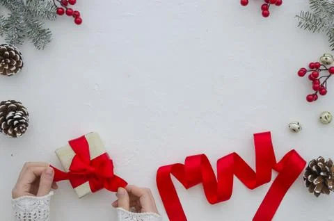 Creative hobby. Woman's hands wrap christmas holiday handmade present with red Stock Photos