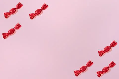 Creative Holiday Pattern Red Chocolates on Pink Background copy space for tex Stock Photos