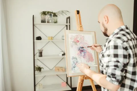 Creative home leisure. Man does easel drawing Stock Photos