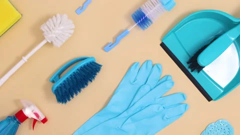 Creative household cleaning tools pattern move on beige background. Stop motion Stock Footage 151483270