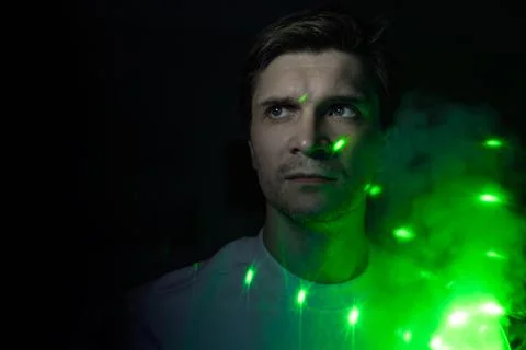 Creative idea, concept. young man and a projection of colored patterns on smoke. Stock Photos