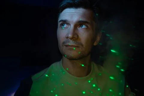 Creative idea, concept. young man and a projection of colored patterns on smoke. Stock Photos