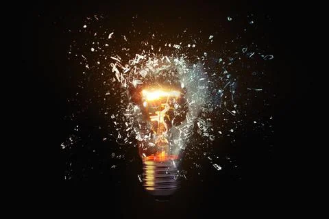 Creative idea light bulb explodes with shards of glass against a dark backg.. Stock Photos