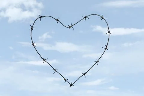 Creative image of heart shape made of barbed wire over blue sky background Stock Photos