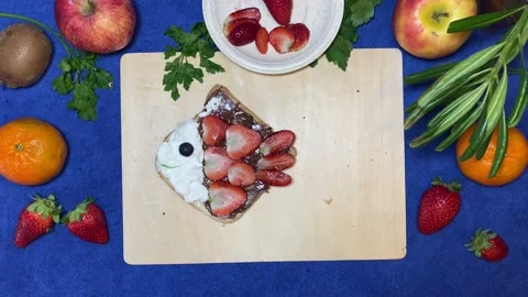 Creative kids breakfast, fish made of chocolate bread spread, strawberries and Stock Footage 239861200