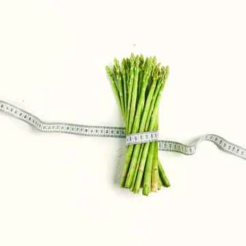 Creative layout asparagus with measuring tape concept diet, healthy lifestyle Stock Photos