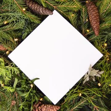 Creative layout of Christmas tree branches with cones and a garland and a pap Stock Photos