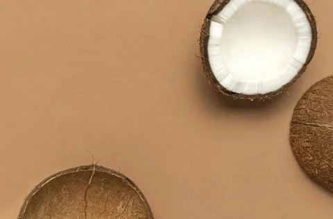 Creative layout with coconuts. Whole and half coconut on brown background Stock Photos