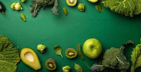 Creative layout food concept made of green fruit and vegetables on green Stock Photos