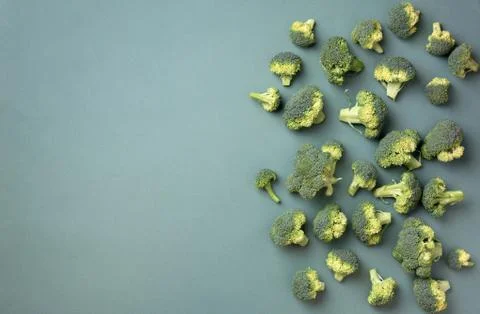Creative layout of fresh broccoli on green paper background. Top view. Food Stock Photos
