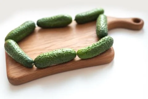 Creative layout of fresh vegetables cucumbers on wooden board on white Stock Photos