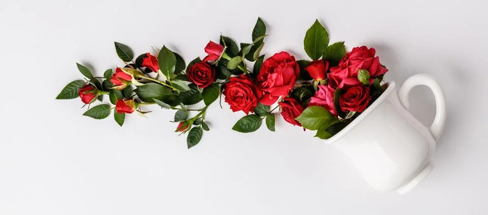 Creative layout made of coffee or tea cup with red roses on white background Stock Photos
