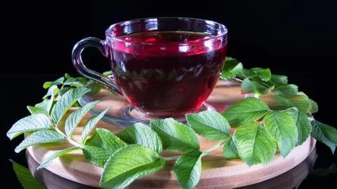 Creative layout made of cup of red tea and tea leafs. Tea time: cup of tea, c Stock Photos