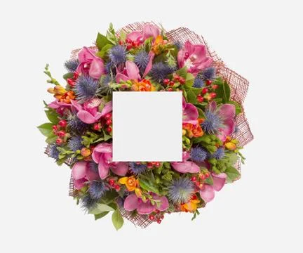 Creative layout made of flowers and leaves with paper card note. Flat lay Stock Photos