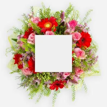 Creative layout made of flowers and leaves with paper card note. Flat lay Stock Photos