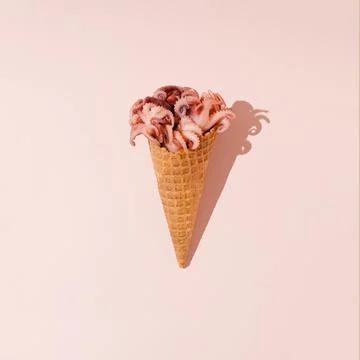 Creative layout made with fresh pink octopuses and ice cream cone. 库存照片