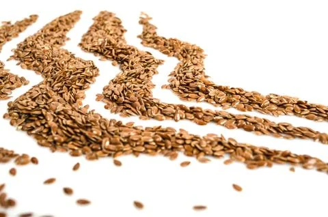 Creative layout made of organic flax seeds isolated on white background. Flat Stock Photos