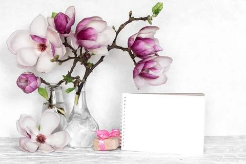 Creative layout made with pink magnolia flowers, empty card and gift box on.. Stock Photos