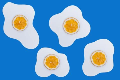 Creative layout made of scrambled eggs with circles of dried orange instead o Stock Photos
