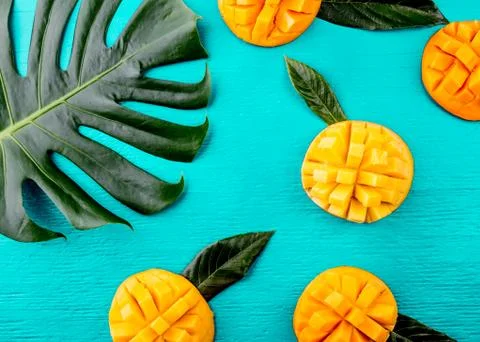 Creative layout made of summer tropical fruits mango and tropical leaves on Stock Photos