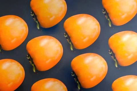 Creative layout of persimmon on a dark background. Food concept. Stock Photos