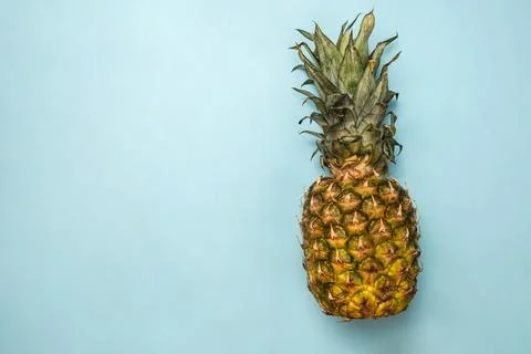 Creative layout of pineapple on a blue background. Flat lay. Food concept. Stock Photos