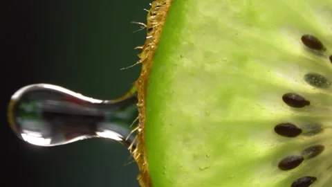 Creative layout of sliced kiwi and water. Splashes on black background. Stock Footage 251905318