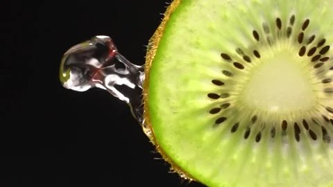 Creative layout of sliced kiwi and water. Splashes on black background. 스톡 동영상 251913170